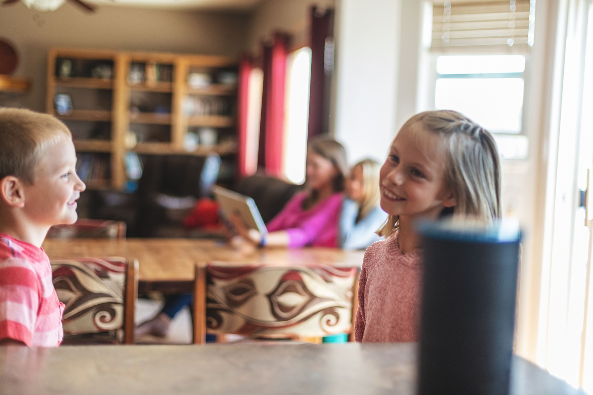 Young Millennial Mother and Children Operating Smart Device Speaker at Home Secure in Western Colorado