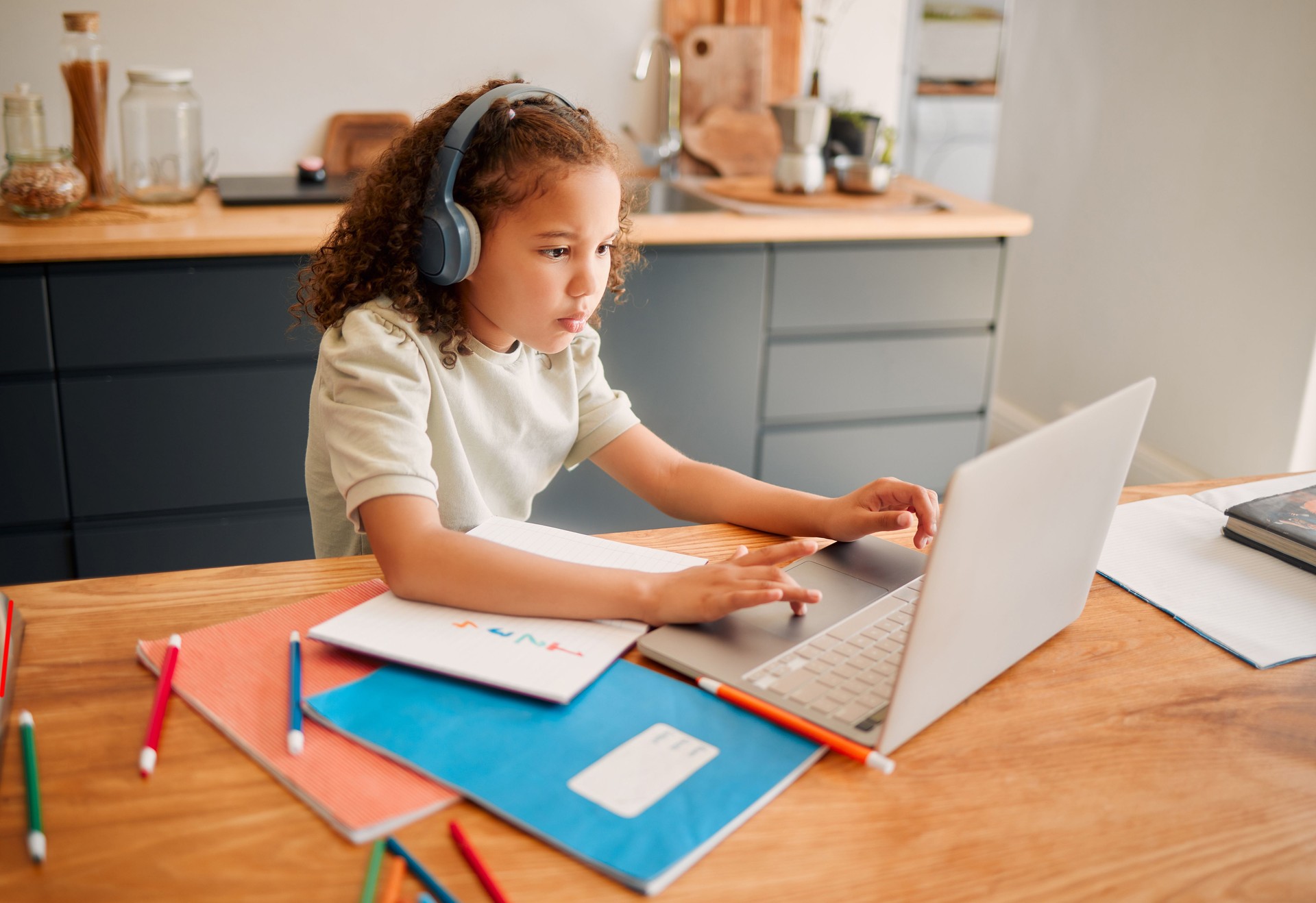 Child education, learning and listening with laptop and headphones for online interactive activity or distance teaching lesson at home. A little, smart and modern student busy with an assignment test